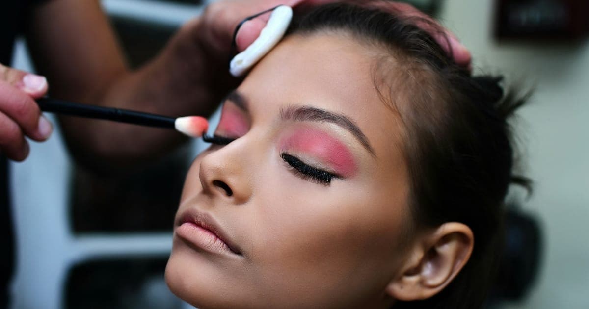 Maquiadora fazendo a maquiagem dos olhos da cliente