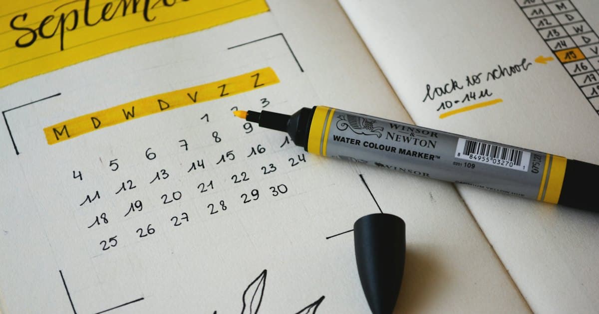 Calendário de papel com marcador e anotações do mês