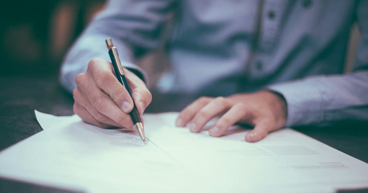 Pessoa assinando um contrato de prestação de serviços