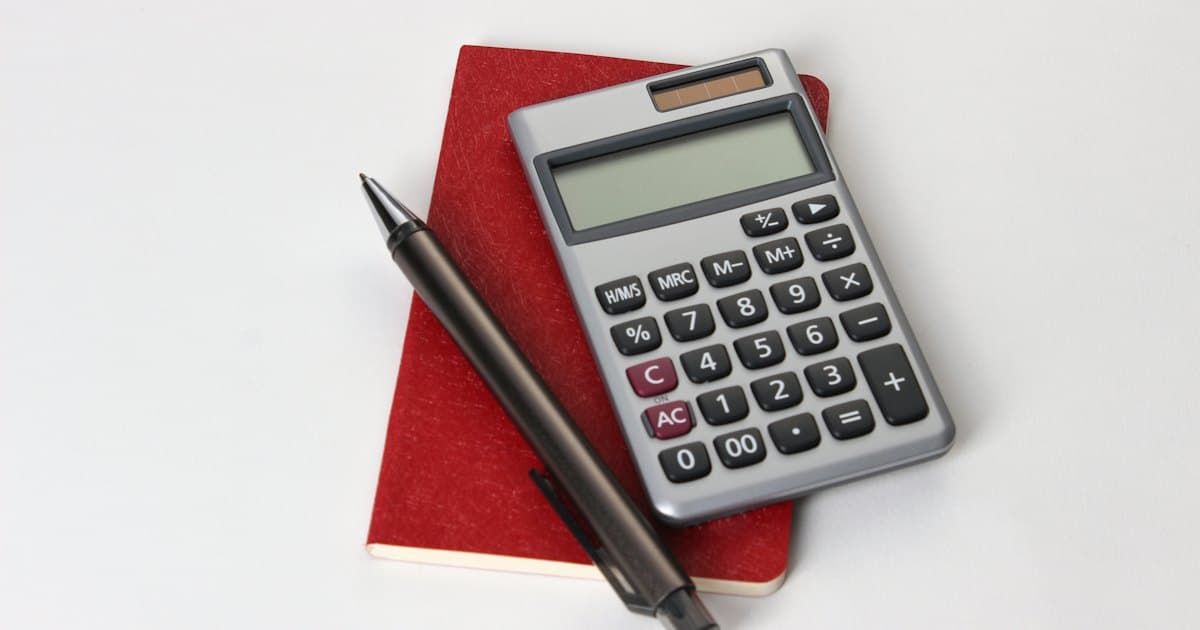 Calculadora e caneta sobre papéis de controle financeiro