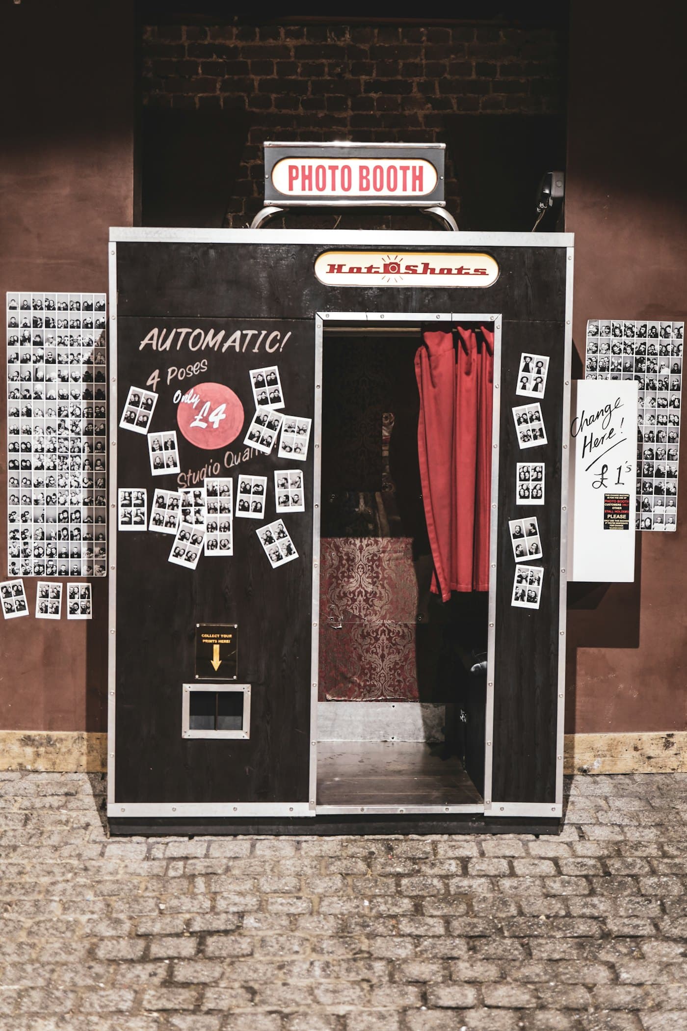 Cabine de fotos com tiras de fotos impressas na parede