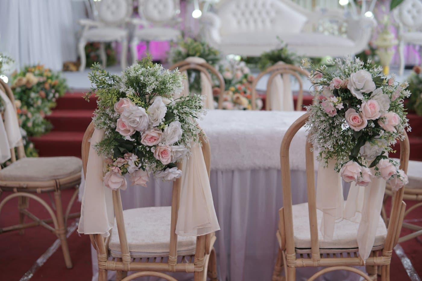 Cadeiras de cerimônia decoradas com arranjos de flores