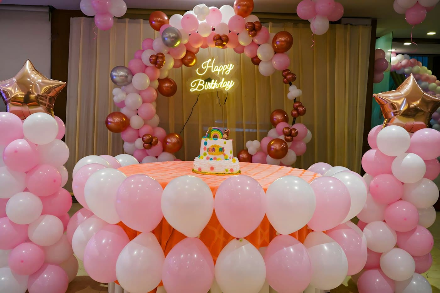 Festa de aniversário decorada com balões e mesa do bolo