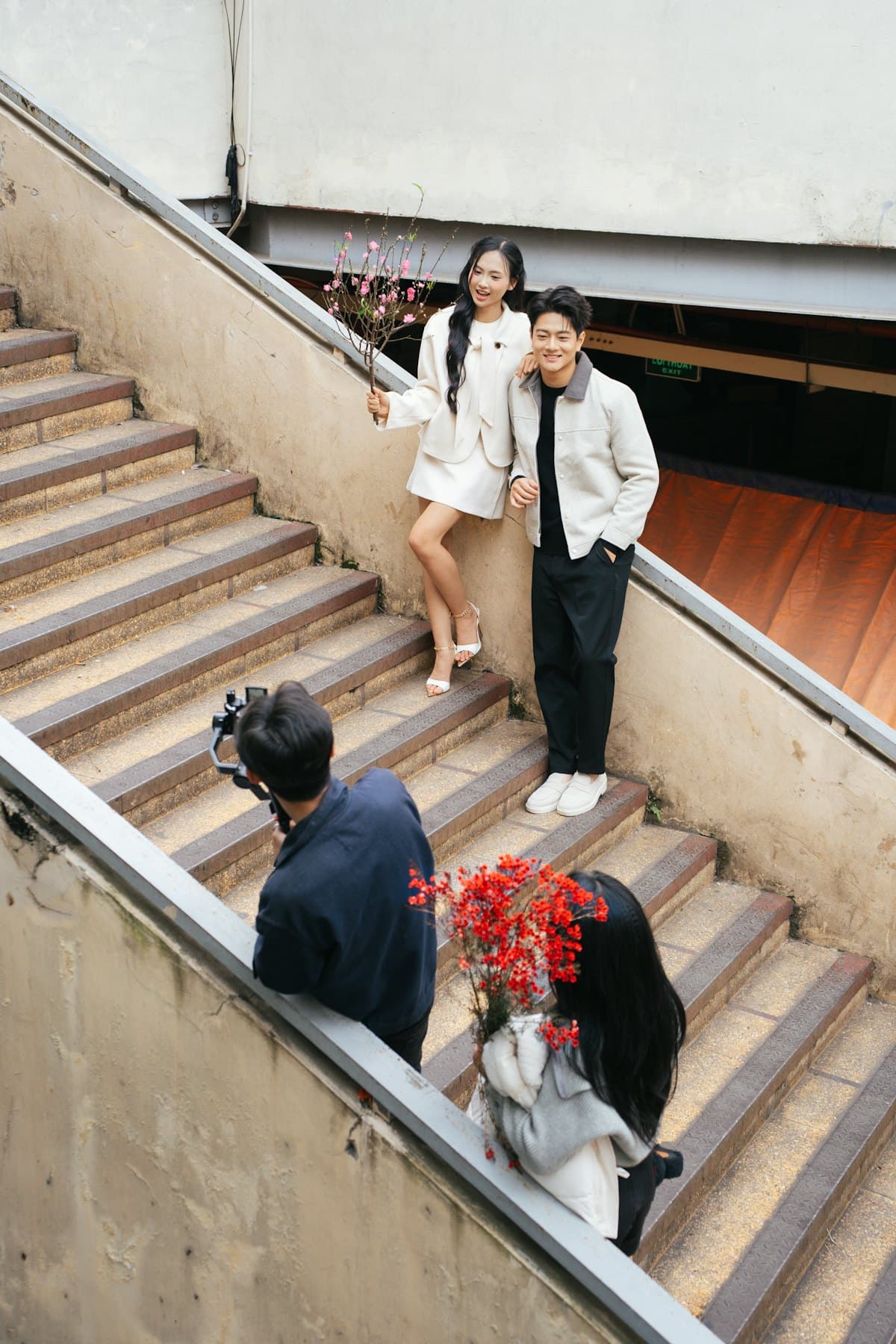 Videomaker filmando um casal de noivos na escada