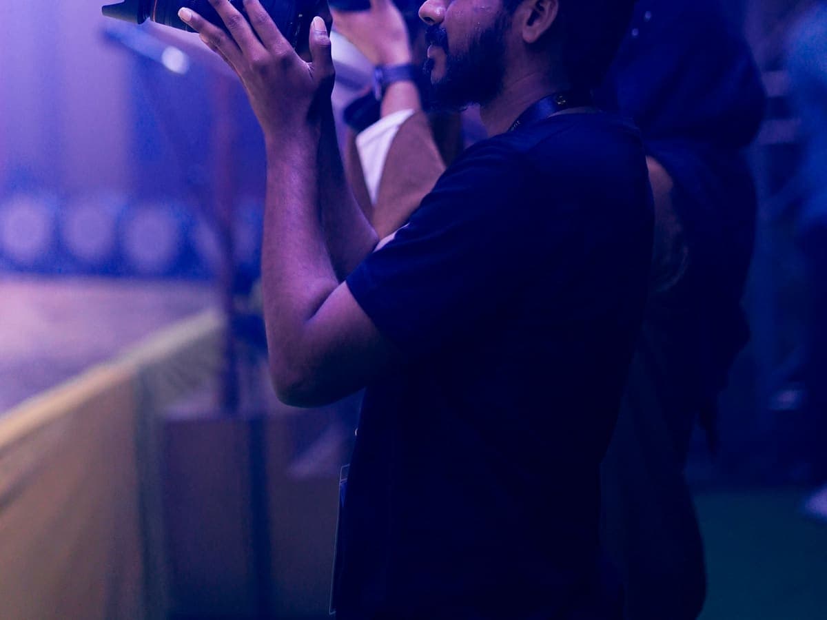 Fotógrafo de eventos clicando sob luz lilás