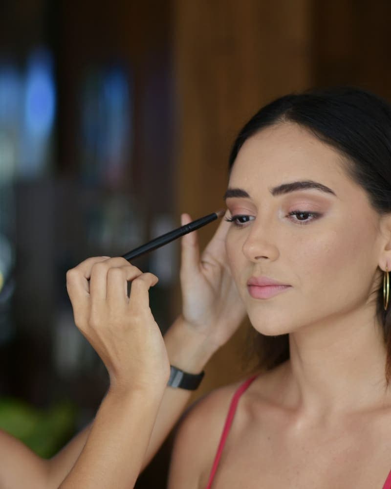 Maquiadora fazendo a maquiagem de uma cliente