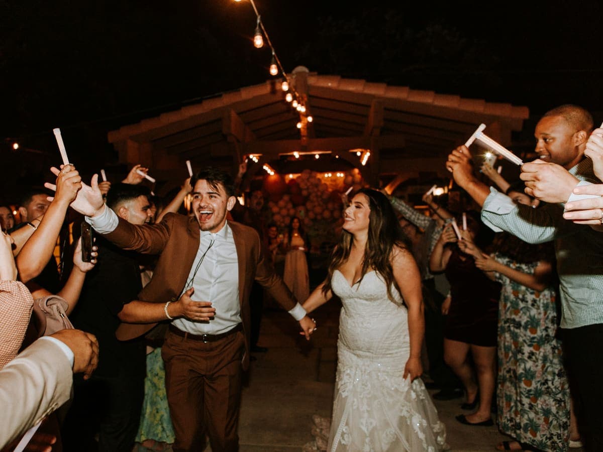 Noivos saindo da festa entre os convidados