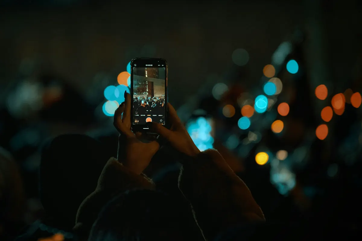 Celular gravando uma festa com luzes ao fundo