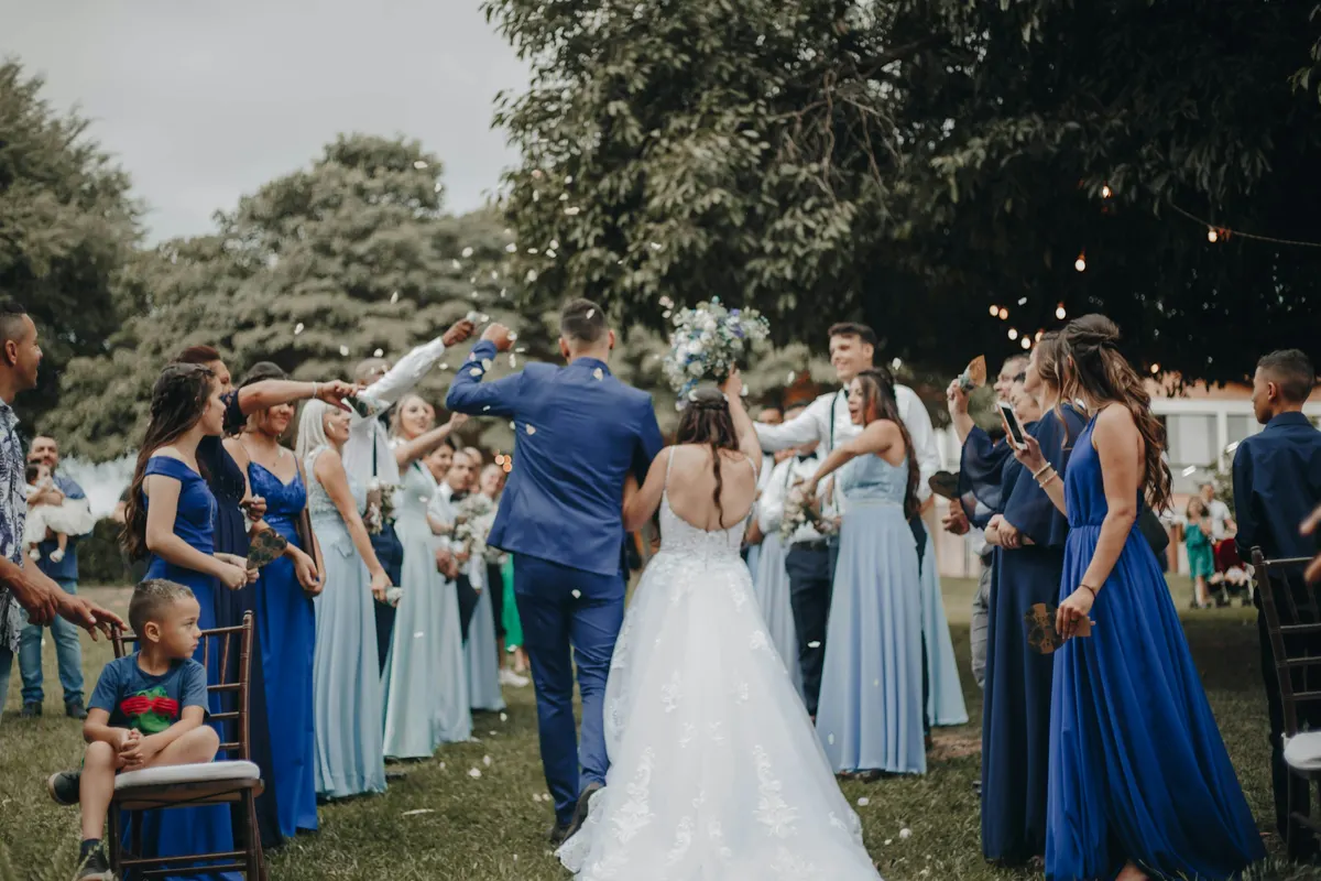 Noivos saindo da cerimônia de casamento entre os convidados